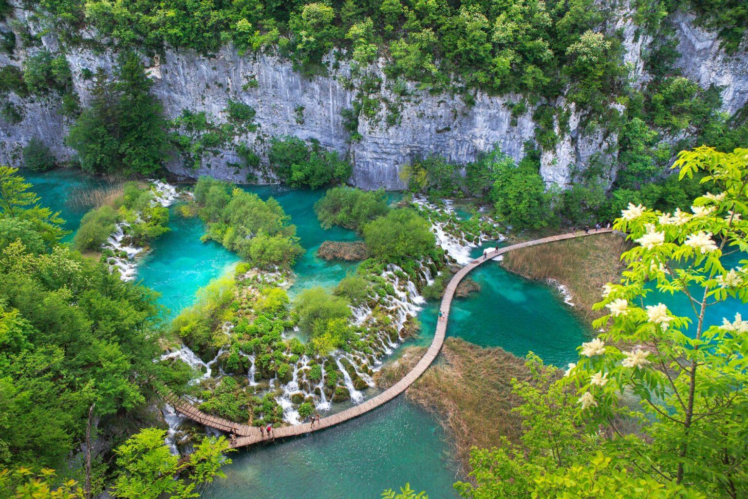 Houten vlonders boven turquoise watervallen in Plitvice Lakes, Kroatië